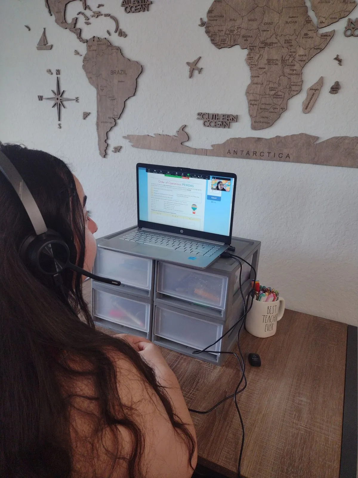 Jayme Riley wearing a headset at an online teaching workspace